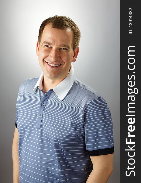 Smiling adult handsome caucasian man over grey background. Smiling adult handsome caucasian man over grey background