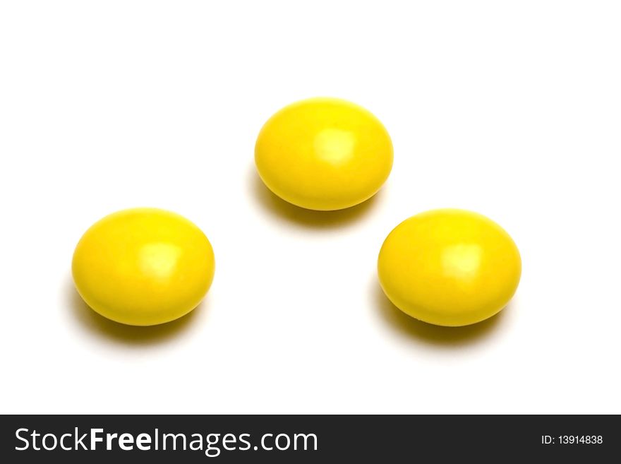 Yellow pills on white background