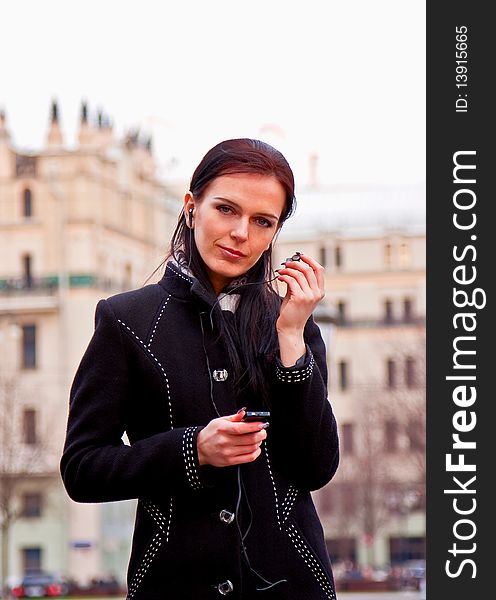 Smiling Girl In Black Coat With Headphones