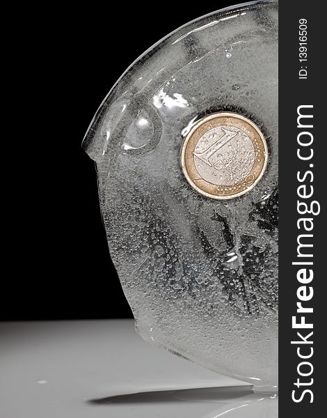 Frozen euro coin on black isolated background