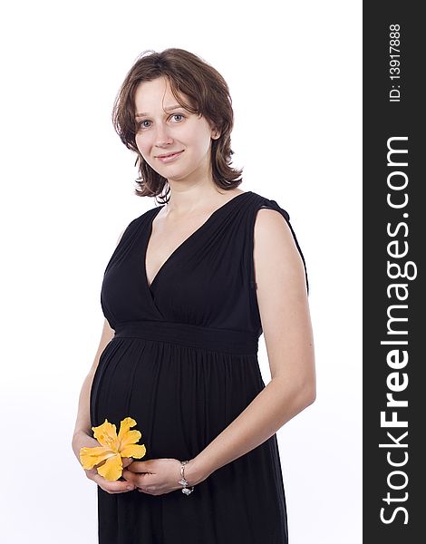 Beautiful pregnant woman in black dress on white background with yellow flower