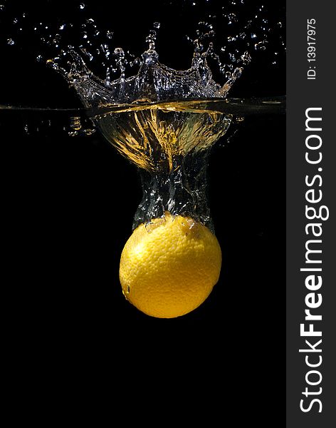 Lemon fall in water on black background