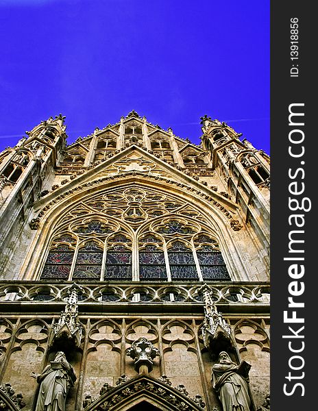 A typical Gothic Cathedral in the old medieval district of Vienna. The image shows a detail of a beautifully colored strained-glass window a trademark of the Gothic architecture. A typical Gothic Cathedral in the old medieval district of Vienna. The image shows a detail of a beautifully colored strained-glass window a trademark of the Gothic architecture.