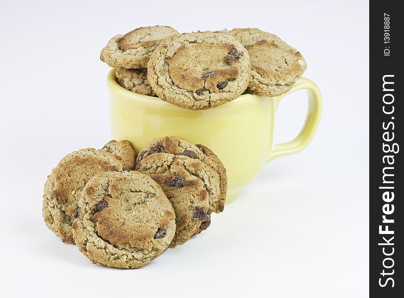 Fresh baked chocolate chip cookies in a yellow cup