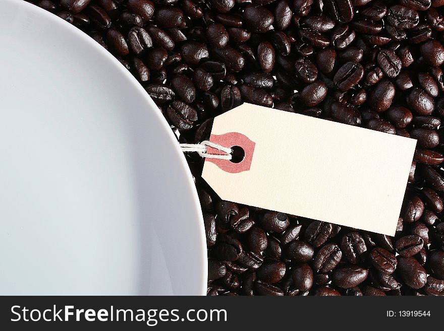 On coffee grains a white plate and a label for an inscription.