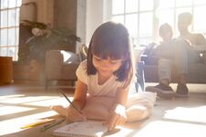 Free Cute Kid Girl Drawing With Colored Pencils Lying On Floor Stock Image - 139193751