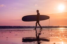 Vacation Silhouette Of A Surfer Carrying His Surf Board Home At Sunset With Copy Space Royalty Free Stock Photos