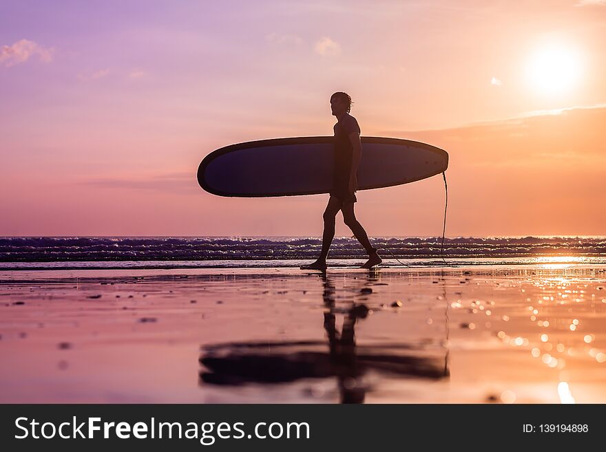 Vacation Silhouette Of A Surfer Carrying His Surf Board Home At Sunset With Copy Space