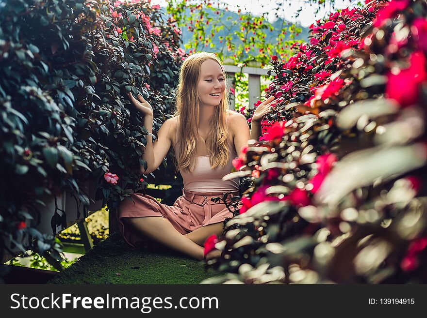 Young woman in a flower greenhouse. Bright tropical flowers..