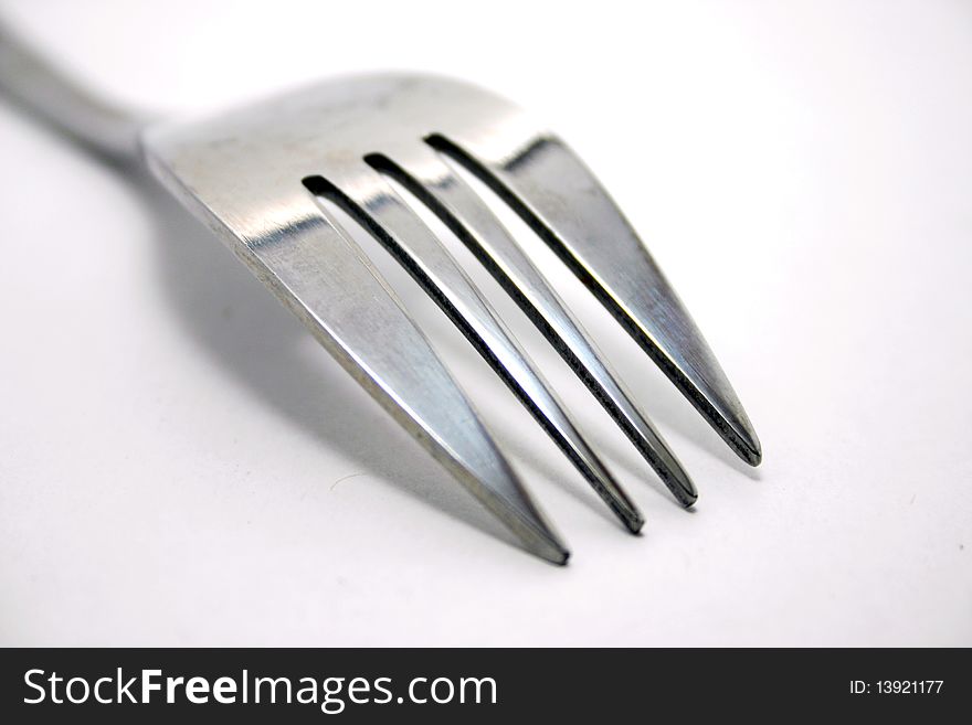 A metal food fork in white background. A metal food fork in white background.