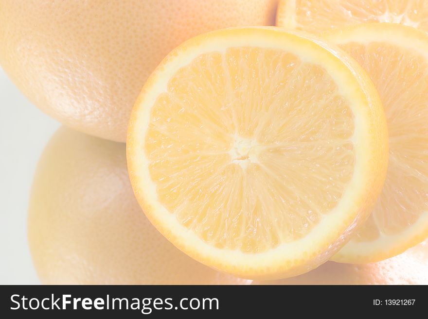 Light, yellow background - an oranges, one orange cut asunder, close-up. Light, yellow background - an oranges, one orange cut asunder, close-up.