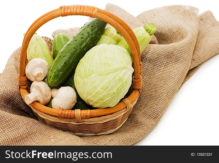 Wattled basket with vegetables isolated on white