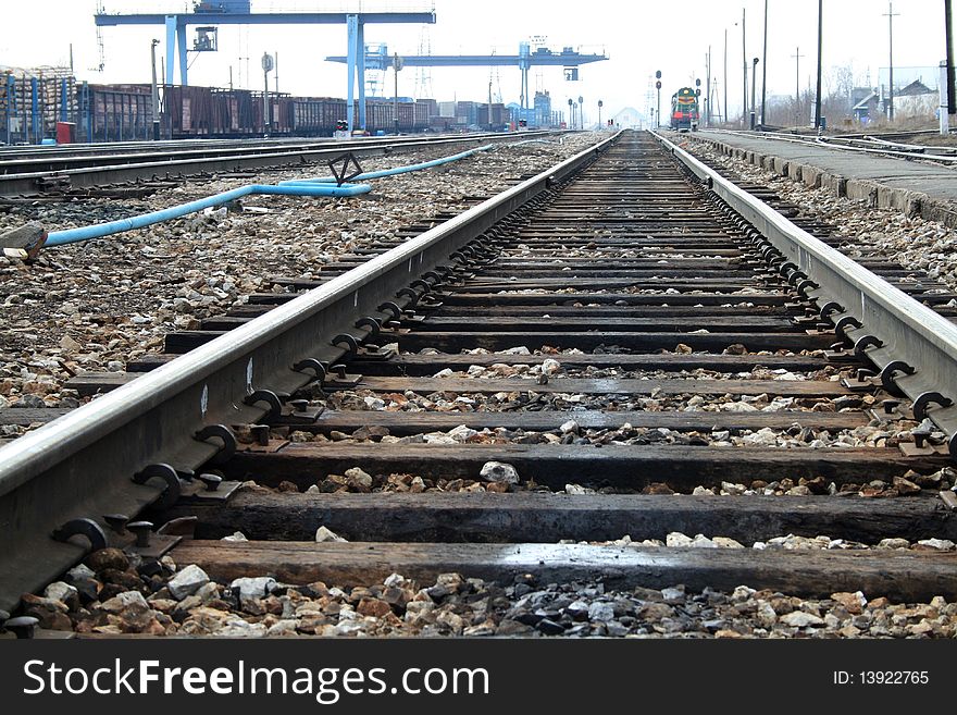 Close-up of the rail, in the background is a train on rails. Close-up of the rail, in the background is a train on rails