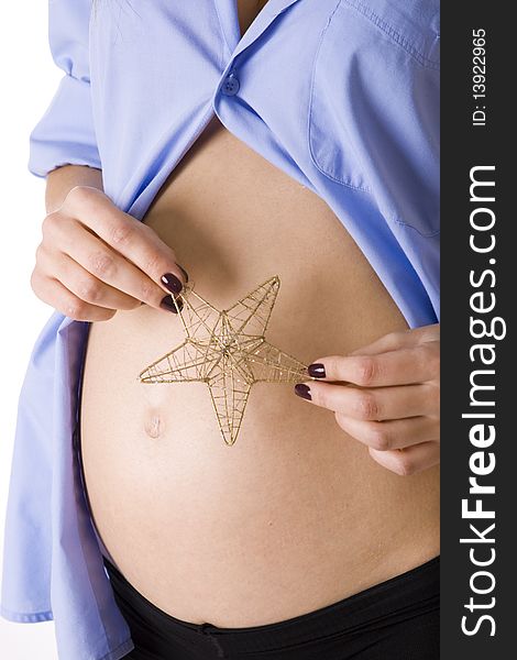 The beautiful pregnant abdomen with a Christmas star. The beautiful pregnant abdomen with a Christmas star