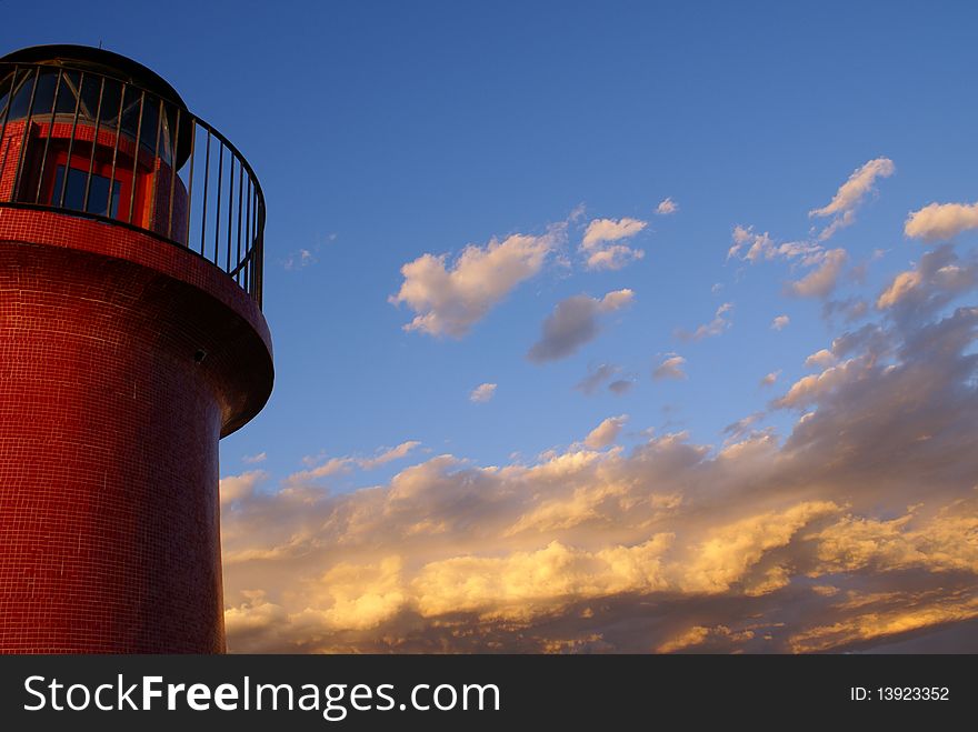 A red lighthouse and the sky with clouds to the horizon.