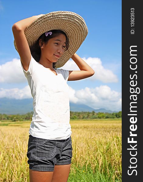 Happy girl standing beside a rice field. Happy girl standing beside a rice field