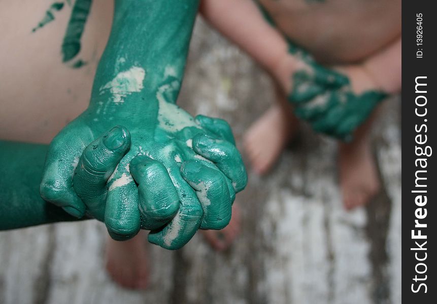 The hands of two children who have been playing with green paint. The hands of two children who have been playing with green paint