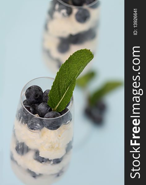 Whipped cream in a glass with blueberries. Whipped cream in a glass with blueberries