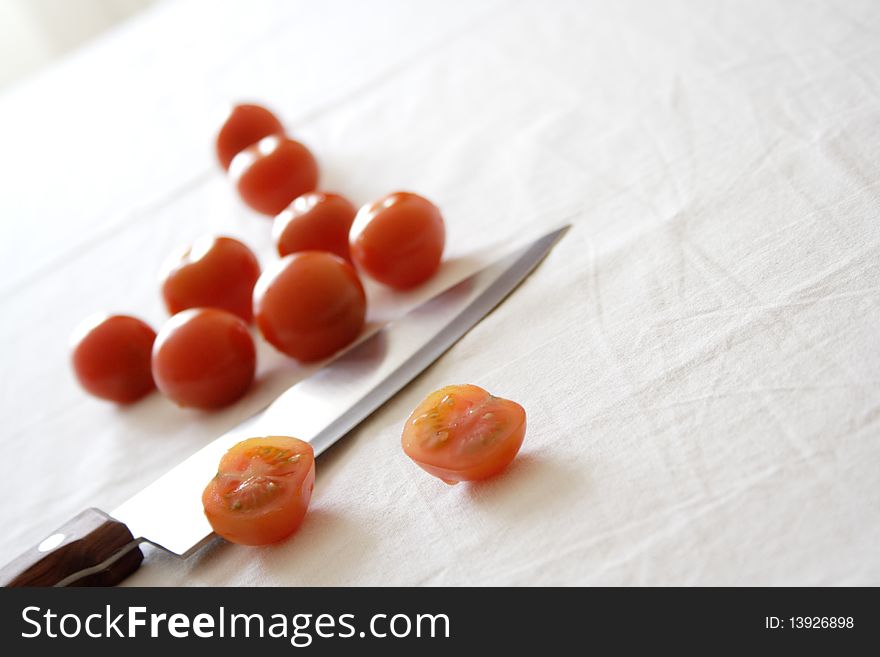 Food set with small cherry tomatoes and a knife. Food set with small cherry tomatoes and a knife