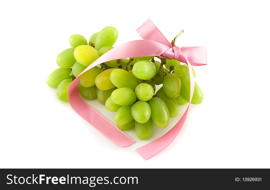 Grapes with a pink bow on white background