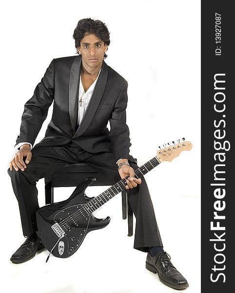 Rock star sitting on chair with a guitar