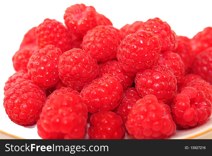 Few red berries are ripe raspberries on the saucer, raspberries on white background. Few red berries are ripe raspberries on the saucer, raspberries on white background