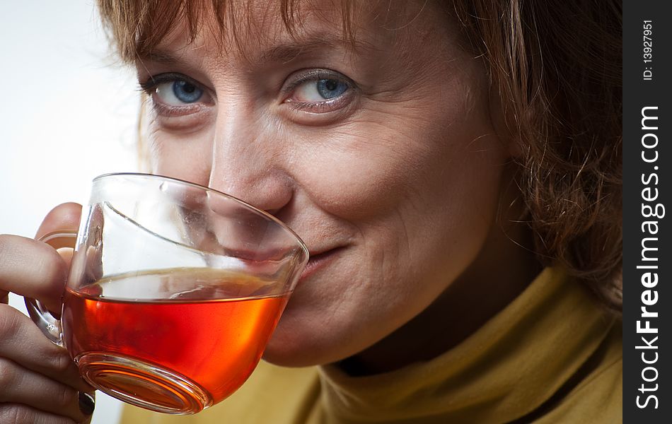 Portrait of a blue-eyed woman in a pale green sweater with a cup tea. Portrait of a blue-eyed woman in a pale green sweater with a cup tea