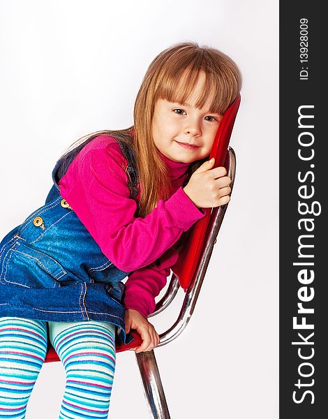 Portrait of the little girl sitting on a chair