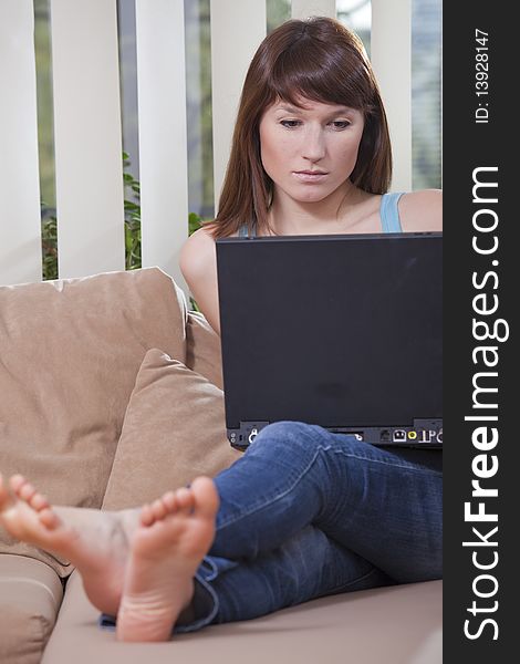 Woman working with laptop at home on the sofa