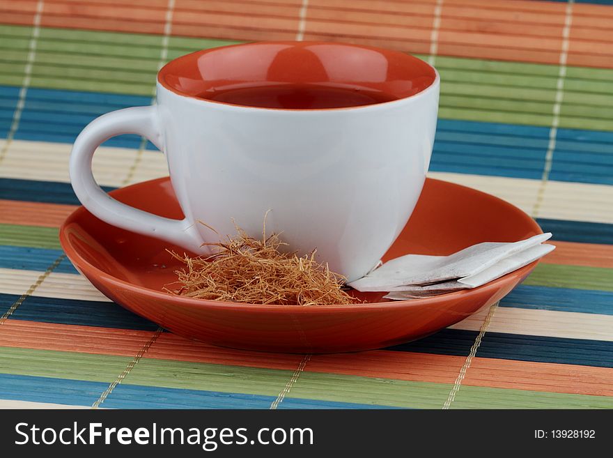 Cup of tea with teabag and sugar.