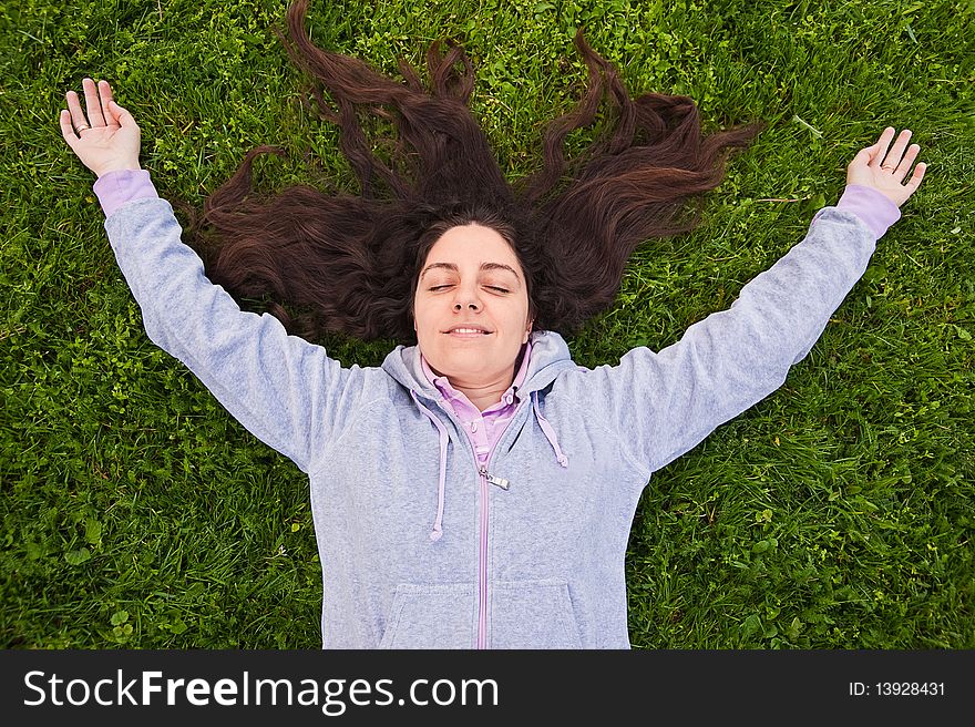 Pretty girl lying on grass, enjoying