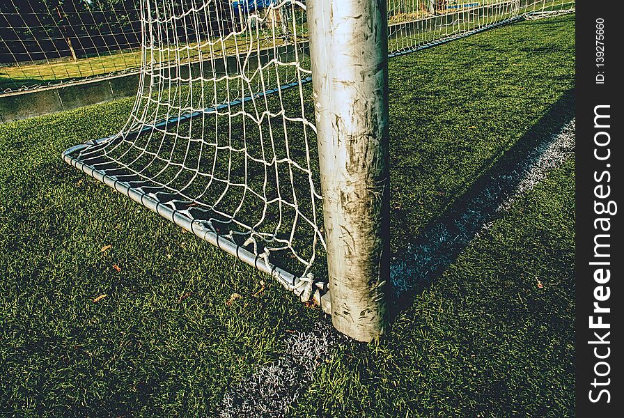 Goal with net and green playing field. Closeup view to football training playground