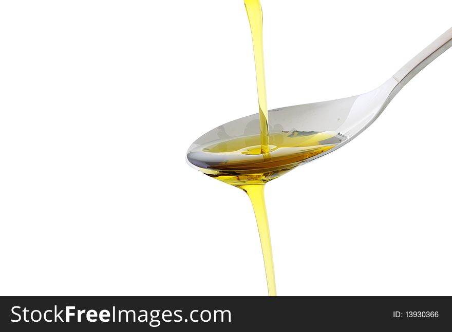 Olive oil being poured into a spoon isolated on white