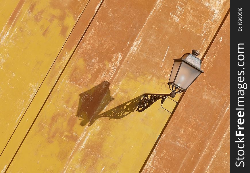 Old stylish brass lantern attached to an old grungy wall. Rome. Italy. Old stylish brass lantern attached to an old grungy wall. Rome. Italy.