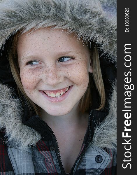 A cute white, caucasian girl child wearing a winter jacket with a big smile on her face. A cute white, caucasian girl child wearing a winter jacket with a big smile on her face.