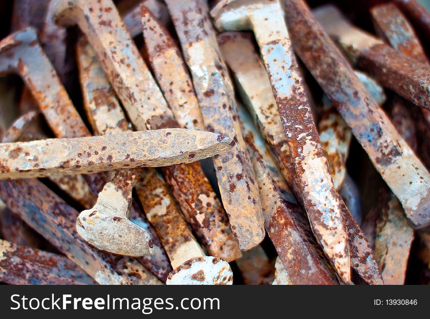 A rusty, grungy pile of railroad spikes. A rusty, grungy pile of railroad spikes