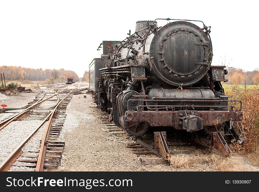 Old half disassembled steam engine on an abandoned track. Old half disassembled steam engine on an abandoned track