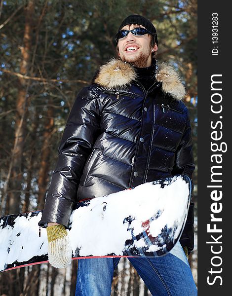 Shot of a handsome young man with a snowboard outdoor. Shot of a handsome young man with a snowboard outdoor.