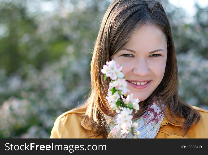 Young woman posing with a blooming branch in a spring park. Young woman posing with a blooming branch in a spring park