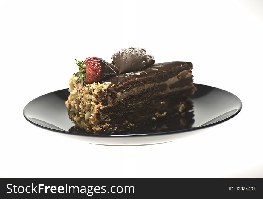 Chocolate cake on the black plate in white background. Chocolate cake on the black plate in white background