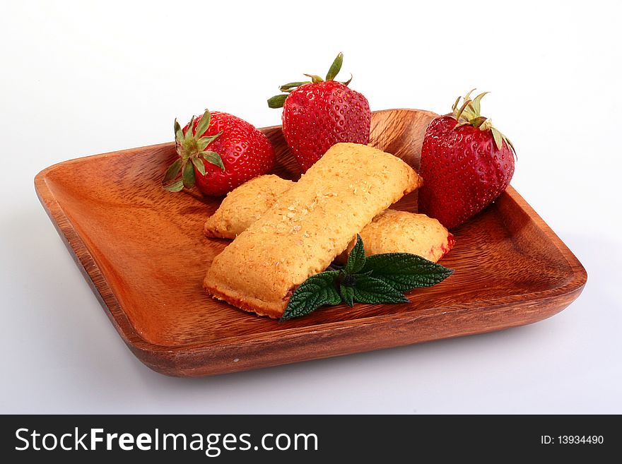 Strawberry with Cereal Bar in a wooden plate with green leaves for a decor.