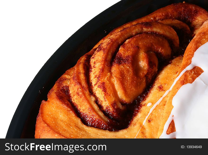 The sweet pie with cinnamon is watered from above by sugar glaze.