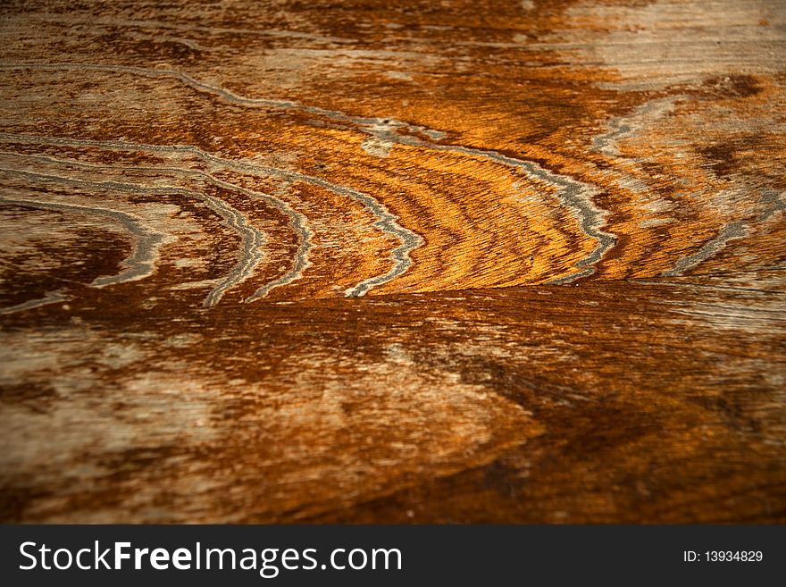 Close up of wooden worn varnished table top with shades of yellow and brown. Close up of wooden worn varnished table top with shades of yellow and brown