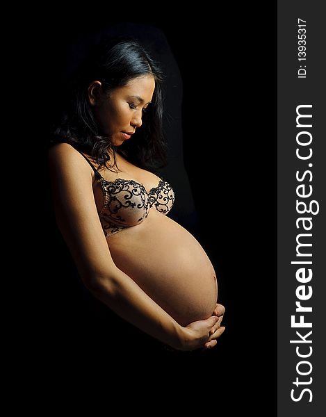 Beautiful woman is 9 months pregnant and poses in studio. Beautiful woman is 9 months pregnant and poses in studio