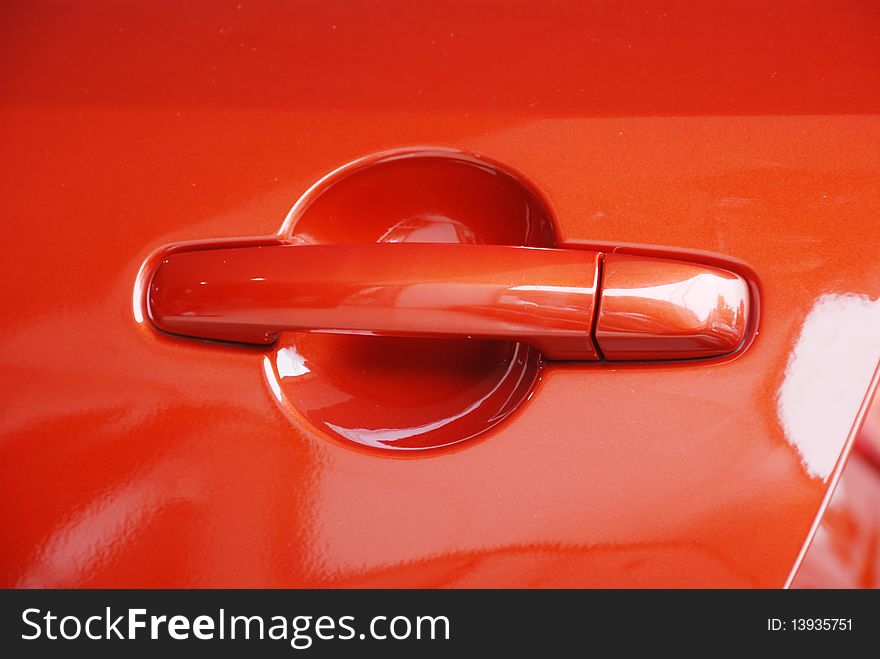 The handle and lock of a red car. The handle and lock of a red car.