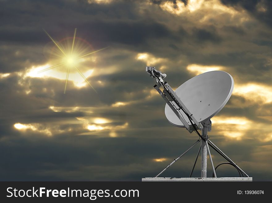 Satellite dish with sun and clouds in the background. Satellite dish with sun and clouds in the background.