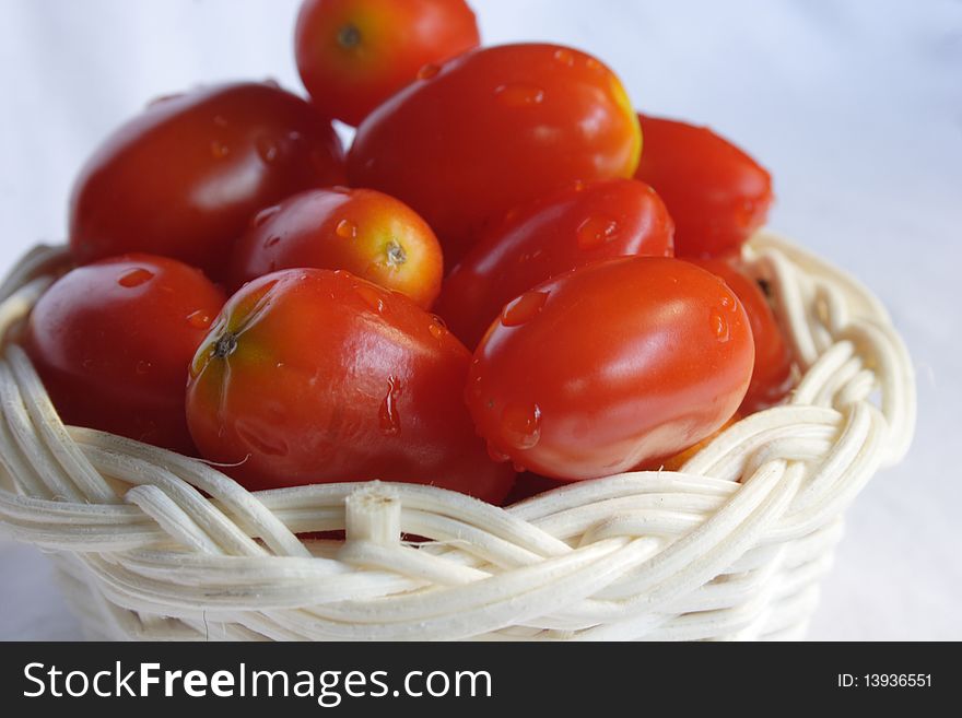 Grape tomatoes in basket with white background