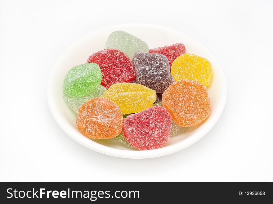 Colorful candy with sugar on top in a small white plate