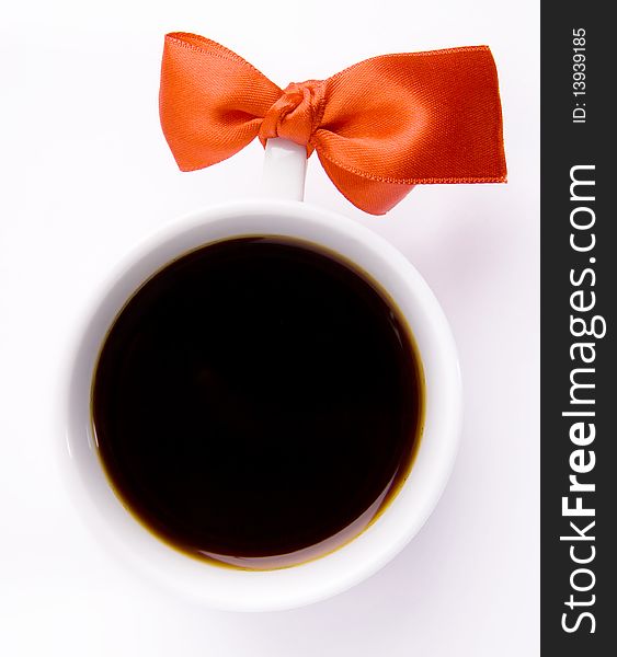 White cup of coffee with a red bow on white background