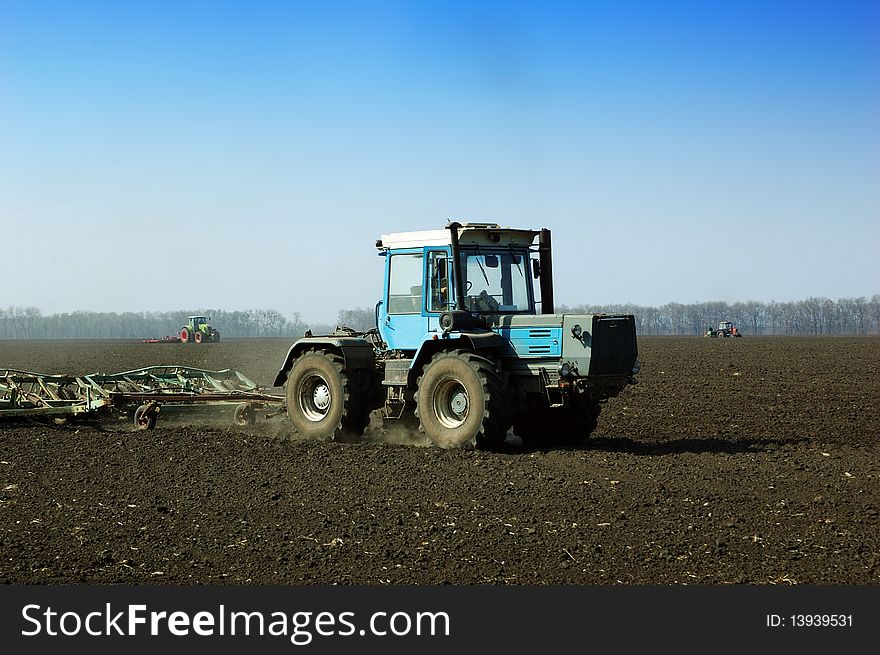 Tractor in the field sow wheat in the spring